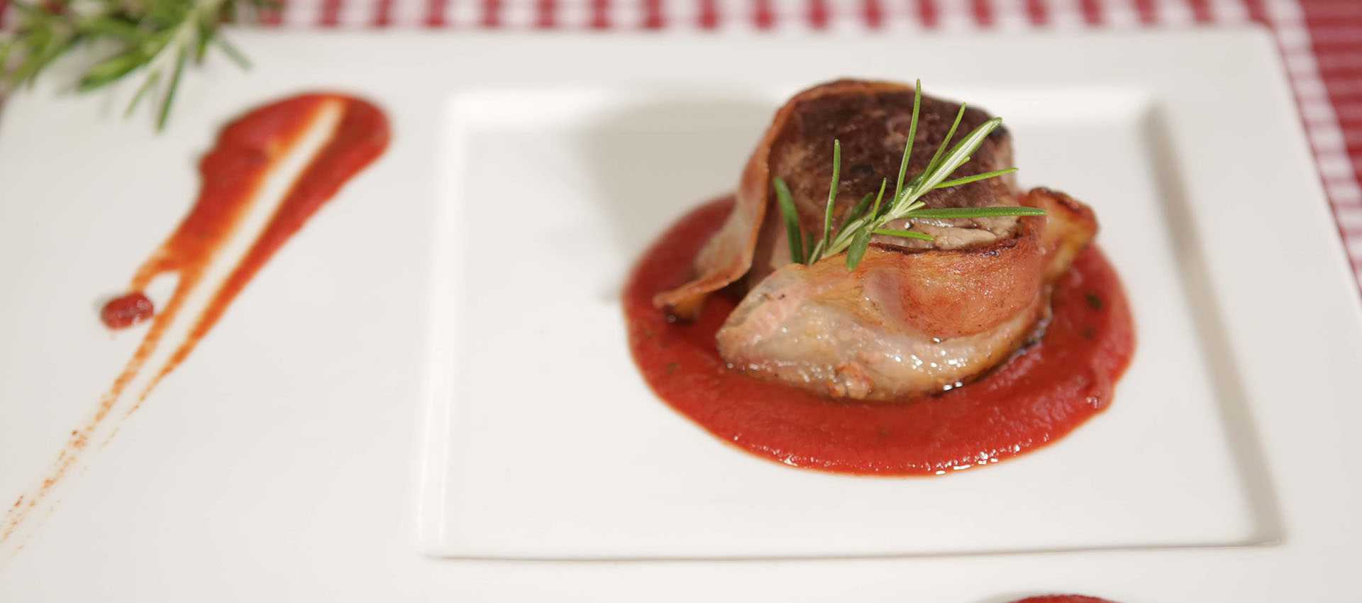 In spek gewikkelde ossenhaasfilet met saus In spek gewikkelde ossenhaasfilet met saus