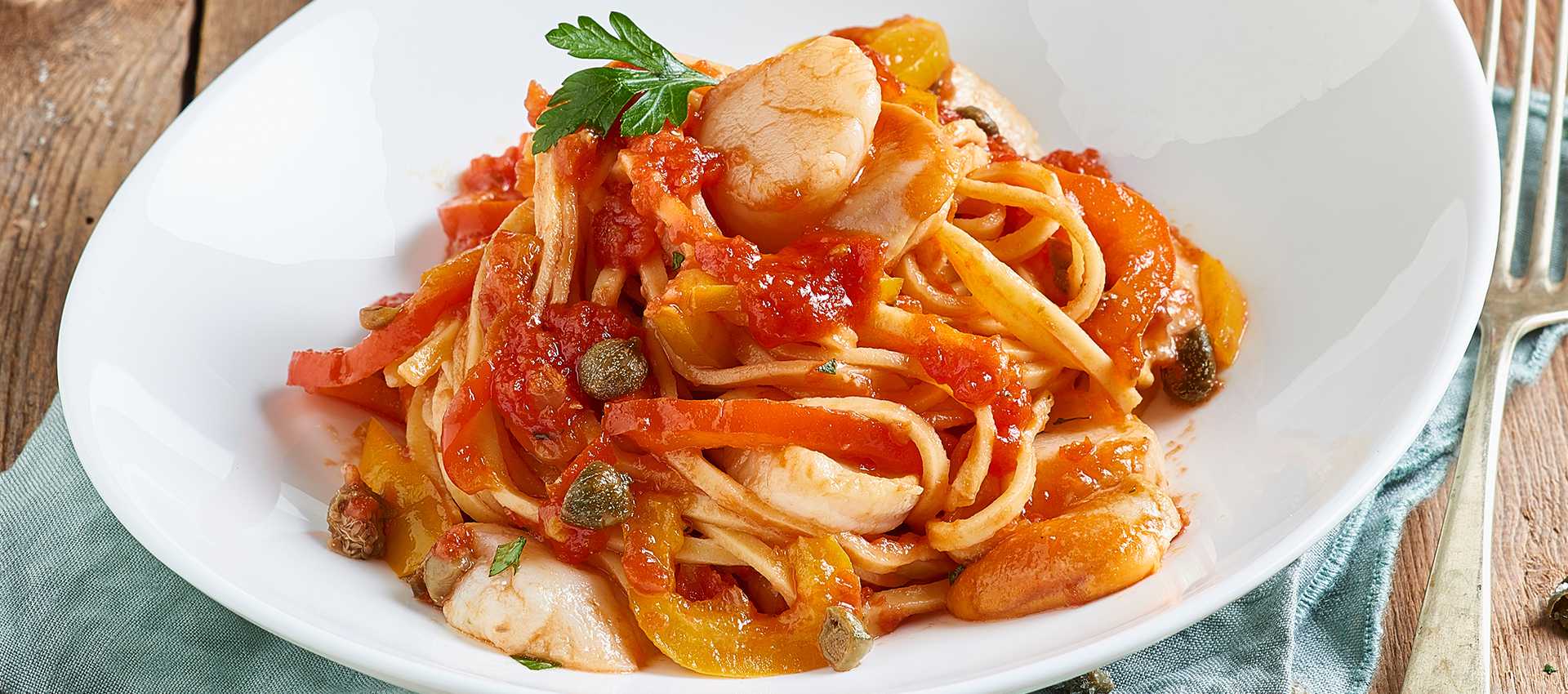 Tagliolini-pastaa paprikoiden, tomaatin, kapristen ja kampasimpukoiden kera Tagliolini-pastaa paprikoiden, tomaatin, kapristen ja kampasimpukoiden kera